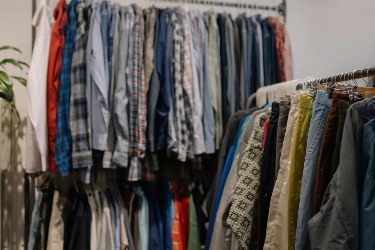 Vestiti usati appesi a una rastrelliera in un negozio dell’usato